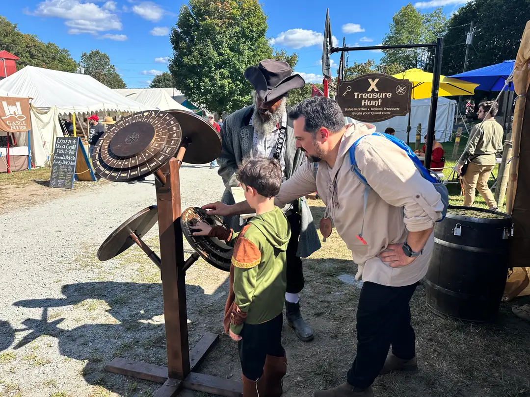 Father and son working the cipher wheel together at X Treasure Hunt