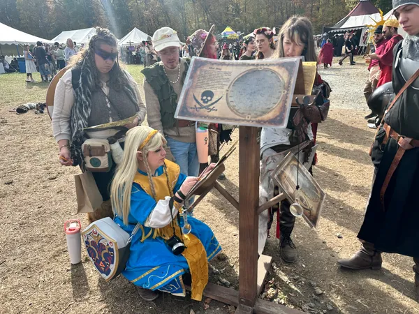 Princess Zelda cosplayer studying pirate star map clues at the faire